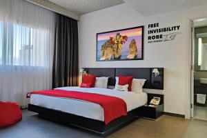 1 dormitorio con 1 cama grande con almohadas rojas en The Smallville Hotel, en Beirut