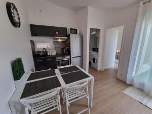kuchnia i jadalnia ze stołem i krzesłami w obiekcie Appartement, terrasse Barcares, proche marché de Noel w mieście Le Barcarès