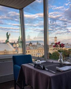 a table with a view of a city from a window at PANORAMA Lviv Hotel in Lviv