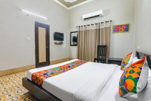 a bedroom with a bed and a television in it at FabHotel Harmony in Colonelganj