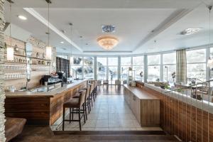 restauracja z barem z mnóstwem okien w obiekcie Gesundheitszentrum Bärenhof w mieście Bad Gastein