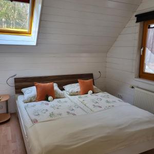 a bedroom with a bed with white sheets and orange pillows at Ferienwohnung MaLu in Aich