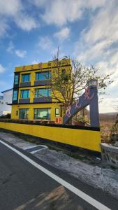 un edificio amarillo al lado de una carretera en Meet Bay B&B, en Xiyu