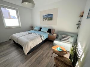 a bedroom with a bed and a couch and a window at Ferienwohnung Dünenhopser in Rostock