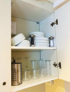 a shelf with dishes and other items on it at Cosy Central Hideaway in St. Leonards