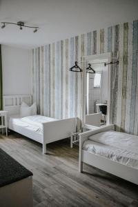 a bedroom with two beds and a mirror at Landgasthof Hotel Will in Neuenstein