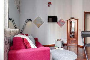 un soggiorno con divano rosa e TV di The Journalist House a Livorno