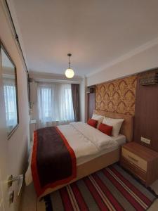 a bedroom with a large bed with red pillows at CLASS SUİT RESİDENCE in Canakkale