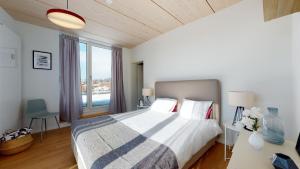 um quarto com uma cama grande e uma janela grande em Magnificent modern apartments in the city center em La Chaux-de-Fonds