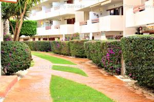 una pasarela frente a un edificio con flores en Gwen El Rincon, en Playa Flamenca