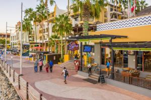 un gruppo di persone che camminano per una strada con edifici di Cabo San Lucas Marina Condos a Cabo San Lucas