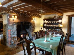 una sala da pranzo con tavolo e camino di The Old Mill Cottage a Okehampton