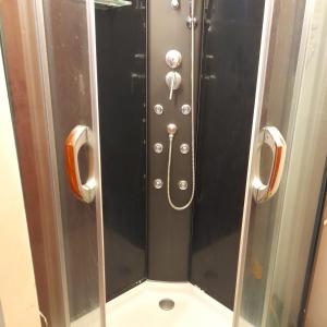 a shower stall with a glass door with buttons and a shower at Omakotitalo ykspihlajassa 110m2 in Kokkola +11 photos