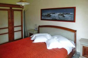 um quarto com uma cama com almofadas brancas em Holiday Home Piriac-sur-Mer - NAT01027-F em Piriac-sur-Mer