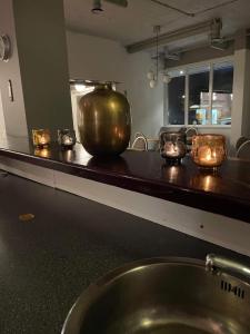 a bathroom counter with a large vase and candles on it at Hotell Eskilstuna in Eskilstuna