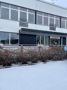 un edificio de oficinas con nieve delante en Hotell Eskilstuna en Eskilstuna