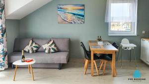 a living room with a couch and a table at Pod Brzozami Apartamenty Górna in Ustronie Morskie