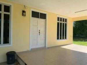 Casa con puerta blanca y patio en Homestay Docmac Wakaf Che Yeh, en Kota Bharu