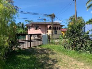 a pink house with a fence in front of it at Homestay Docmac Wakaf Che Yeh in Kota Bharu