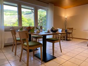 una sala da pranzo con tavolo, sedie e finestra di Haus Schatzgarten a Traben-Trarbach