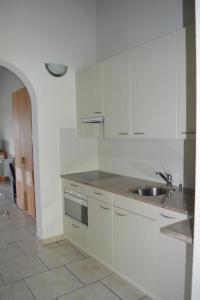 a kitchen with white cabinets and a sink at Residenza Viramonte, Casa Daniela, Appartement 37 in Vira