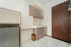 a kitchen with a sink and a wooden door at RedLiving Apartemen Riverview Residence - TOHA Room Tower Mahakam in Tegalgede
