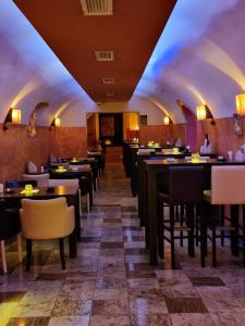 a restaurant with a row of tables and chairs at Fantastico Exlcusive Hotel in Senta