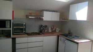 a kitchen with white cabinets and a counter top at L'arbrissel in Fontevraud-l'Abbaye