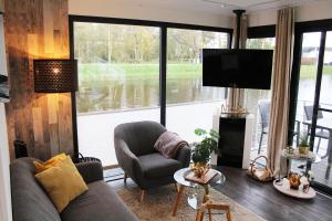 un soggiorno con divano, sedia e ampia finestra di HB 5 - Hausboot Bad Bederkesa a Bad Bederkesa