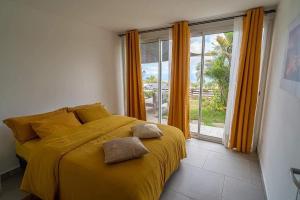 een slaapkamer met een geel bed en een raam bij Villa, Lossy in Le Tampon