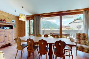 a dining room with a wooden table and chairs at Apartment Sur Puoz 1A in Samedan