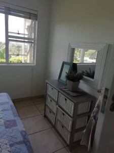 a bedroom with a dresser and a mirror at Dadda's Place 2 in Port Shepstone