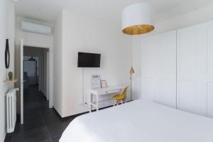 een witte slaapkamer met een wit bed en een bureau bij CASA CATTARINETTI - VERONA FIERA in Verona