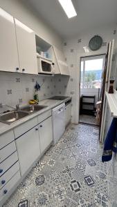 uma cozinha com armários brancos e piso em azulejo em Estartit Delta 4C em L'Estartit