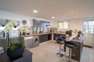 a large kitchen with stainless steel appliances and a table and chairs at Villa, Lossy in Le Tampon