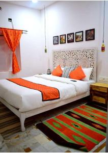 a bedroom with a large bed with orange pillows at Royal Gharana in Jaisalmer