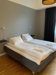 a large bed with white sheets and pillows on it at Hotell Eskilstuna in Eskilstuna