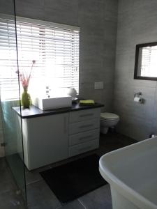 a bathroom with a tub and a sink and a toilet at Tranquility by the sea in Cape Town