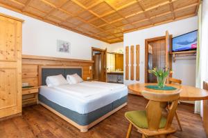 Schlafzimmer mit einem Bett und einem Tisch in der Unterkunft lechner living apartments in Wald im Pinzgau