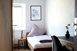 a small bedroom with a bed and a window at Hotel Garni Moers in Moers