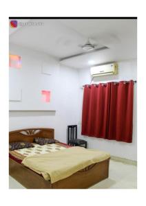 a bedroom with a bed and a red curtain at Dice Villa rooms in Alibaug