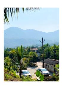 two cars parked in a parking lot with palm trees at Dice Villa rooms in Alibaug