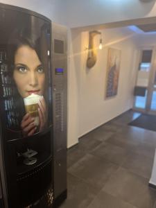 a woman holding a cup of coffee in a elevator at Hotel Garni Moers in Moers