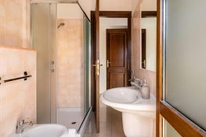 a bathroom with two sinks and a glass shower at Bellissimo Appartamento Centrocittà in Olbia