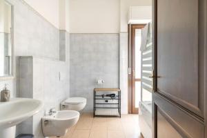 un bagno bianco con lavandino e WC di Dimoras Bellissimo Appartamento Centrocittà a Olbia
