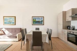 a kitchen and dining room with a table and chairs at Dimoras Bellissimo Appartamento Centrocittà in Olbia