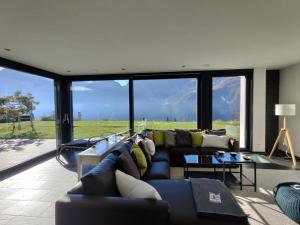 ein Wohnzimmer mit einem Sofa und einem großen Fenster in der Unterkunft Ferienvilla am See 3 für 2-4 Personen in Sisikon