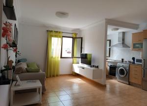 a living room with a couch and a kitchen at Casa Calderetas in San Bartolomé