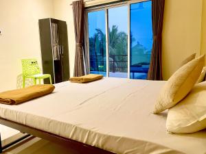 a bed in a room with a large window at Scarlet Resort Alibag in Alibaug