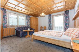a bedroom with a bed and a chair at lechner living apartments in Wald im Pinzgau